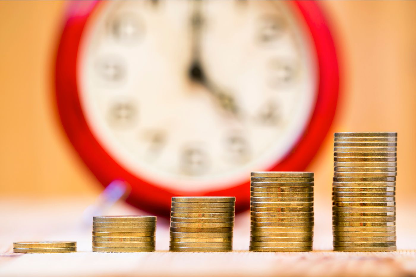 Compounding interest respresented with coins and clock