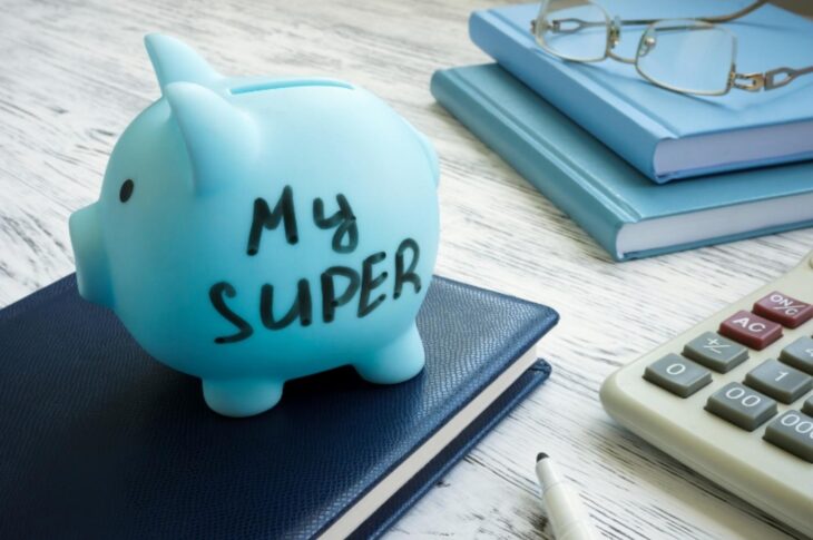 Blue piggy bank labelled "my super" with books and calculator in background