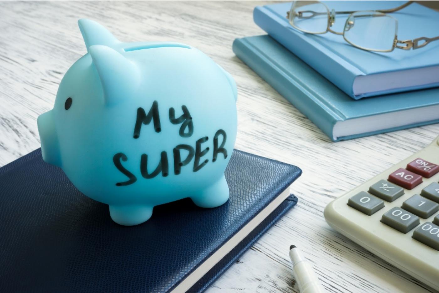 Blue piggy bank labelled "my super" with books and calculator in background
