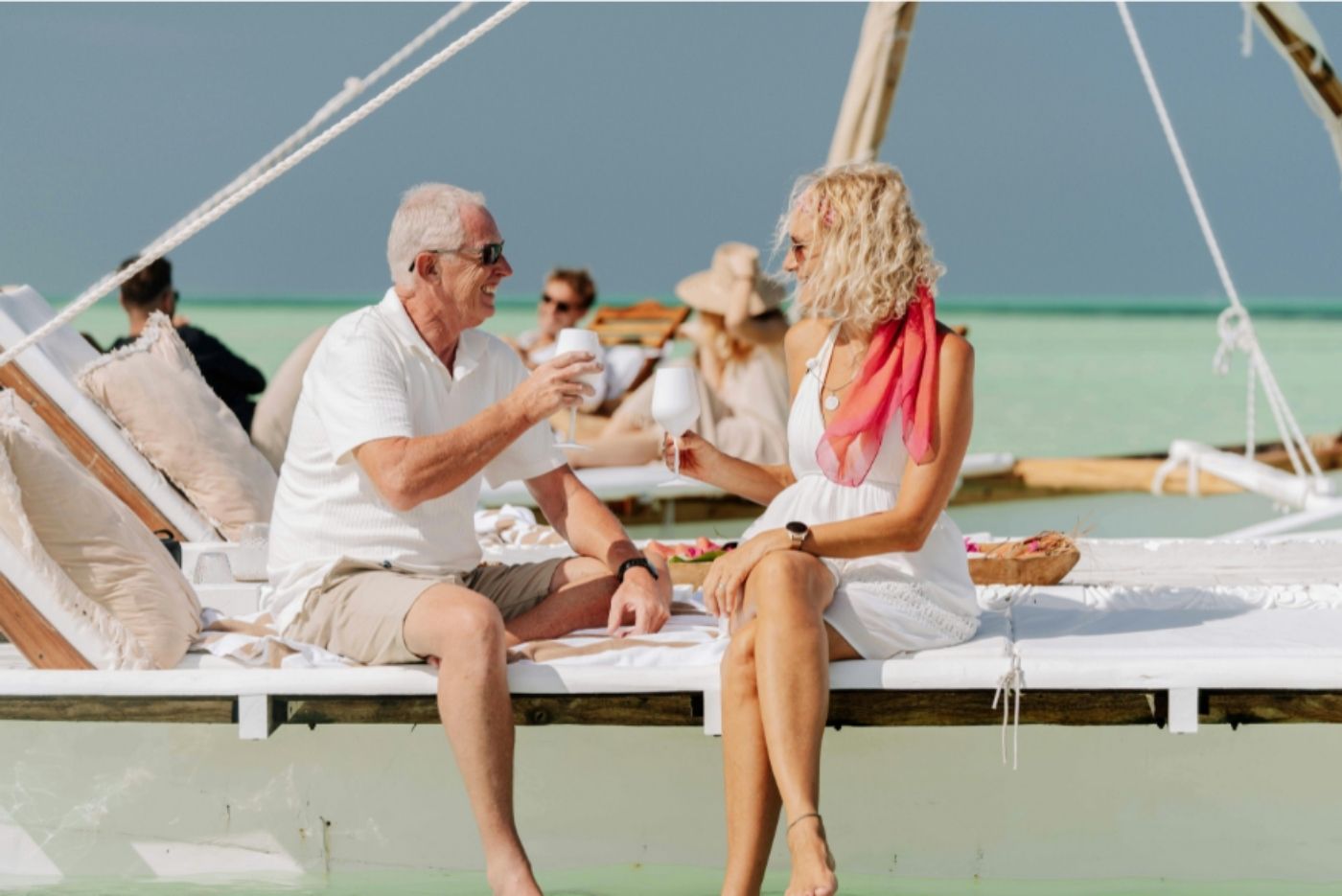 Elderly couple enjoying drinks in scenic water spot