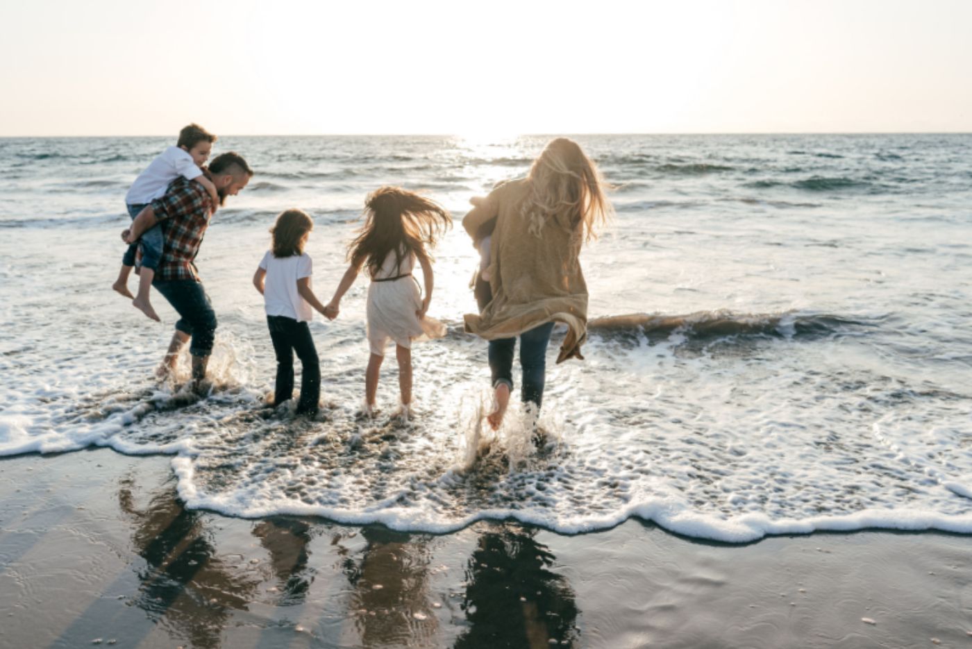 Family playing together in the waves on the beach Family playing together in the waves on the beach